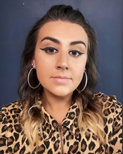 headsot of a woman in a leopard print top