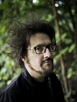 Image of a white man with sticking up black hair on green