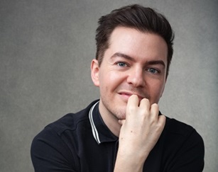 Headshot of a white man against grey