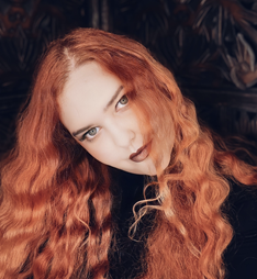 Image of a white woman with red hair with her head at an angle