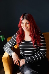 Image of a woman with red hair sitting on a sofa