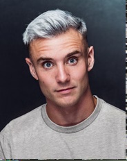 Headshot of a white man against a grey background