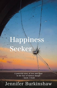 Book cover for HAPPINESS SEEKER: title in white on sunset seen through a fractured window