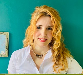 Headshot of a white woman with blonde hair against a teal wall