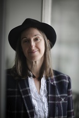 Image of a white woman in a hat on grey