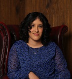 Image of a brown-skinned woman in blue sitting in a big armchair