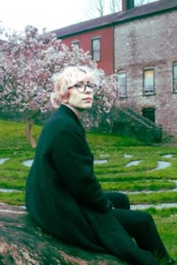 Author photo of a white person with short hair and a dark coat sitting outside