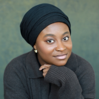 Head shot of a Black woman with a black head wrap