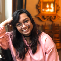 Photo of a Brown woman in a pink top indoors