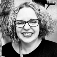 Black and white headshot of a woman with curly hair