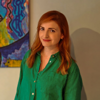 Image of a white woman with red hair in a green top