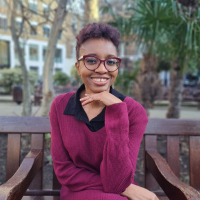 Photo of a Black woman on a park bench