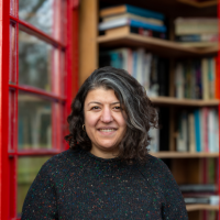 photo of a woman in front of library inside a phone box