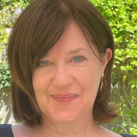 headshot of a white woman with leaves behind