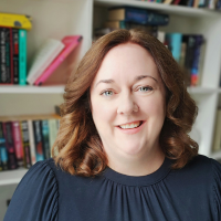 Headshot of a white woman against bookshelves