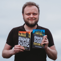Photo of a white man in a black top holding two books