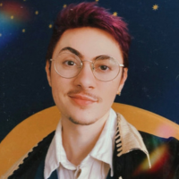 Photo of a person with short purple hair against a blue backdrop