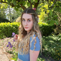 Photo of a white woman with wavy hair in a garden