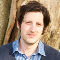 Headshot of a white man against tree bark