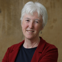 Head shot of a white woman with white hair against brown