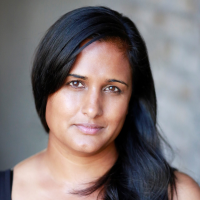 Headshot of a brown woman with dark hair over one shoulder