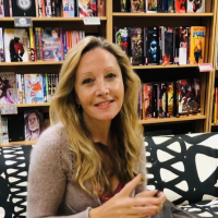 Photo of a white woman with long blonde hair inside a bookshop
