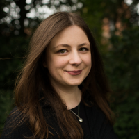 Headshot of a white woman with brown hair outside