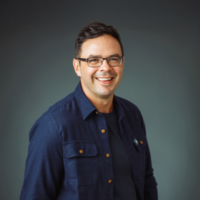 Headshot of a white man in a navy shirt