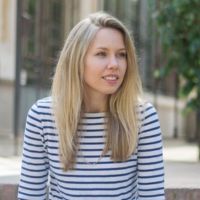 headshot of a white woman with blonde hair in a striped top outside