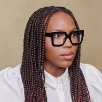 Headshot of a Black woman with long, dark braided hair