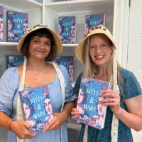Image of two white women holding books and wearing bonnets